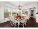Sunlit dining room with a wooden table, white chairs, and views from large windows at 2921 Terra View Sw Dr, Lilburn, GA 30047