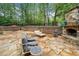 Backyard patio with stone fireplace and ample seating nestled amongst mature trees at 3252 Custer Lake Drive Northwest Nw Dr, Marietta, GA 30064