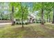 Exterior view of a charming white brick home nestled among lush trees and a well-maintained lawn at 3252 Custer Lake Drive Northwest Nw Dr, Marietta, GA 30064