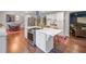 Open kitchen featuring stainless appliances, a center island with seating, and hardwood floors flowing into an adjacent living space at 3252 Custer Lake Drive Northwest Nw Dr, Marietta, GA 30064