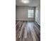 This bedroom has wood-like flooring, a window, and a door that add style at 1230 Chris Lake Dr, Lawrenceville, GA 30046