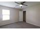 A bright bedroom with a ceiling fan, window and neutral walls with wall to wall carpeting at 315 Lakeside Ln, Woodstock, GA 30188