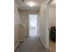 Hallway leading to a carpeted room and featuring a laundry room with a washer and dryer at 315 Lakeside Ln, Woodstock, GA 30188