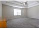 Spacious carpeted main bedroom with a tray ceiling and ceiling fan at 315 Lakeside Ln, Woodstock, GA 30188