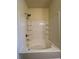 Bathroom featuring a white tiled bathtub-shower combo with shelving at 664 Oakside Pl, Acworth, GA 30102