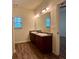 Bathroom vanity with double sinks, large mirror and wood-look flooring at 664 Oakside Pl, Acworth, GA 30102
