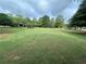 Expansive green space with mature trees and pergola creating a welcoming outdoor environment at 664 Oakside Pl, Acworth, GA 30102