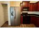 Well-lit kitchen featuring stainless steel refrigerator, dark cabinets, and black countertops at 664 Oakside Pl, Acworth, GA 30102