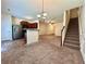 Open living space featuring carpet, kitchen bar, staircase, and stainless steel refrigerator at 664 Oakside Pl, Acworth, GA 30102