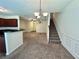 Open floor plan with a kitchen bar, stairs, and carpeted living room at 664 Oakside Pl, Acworth, GA 30102