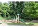 Community playground featuring a slide and climbing structure, surrounded by benches and lush greenery at 664 Oakside Pl, Acworth, GA 30102