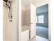 Clean white bathtub and modern shower head with a view into an adjacent bedroom with natural light at 2709 Heathrow Dr, Lawrenceville, GA 30043