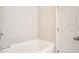 Cozy bathroom featuring a clean white bathtub and a standard shower head, with a white door at 2709 Heathrow Dr, Lawrenceville, GA 30043