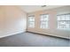 Bright bedroom featuring neutral walls, plush carpeting, and three windows allowing ample natural light at 2709 Heathrow Dr, Lawrenceville, GA 30043