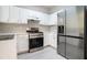 Well-lit kitchen with white cabinets, stainless steel appliances, and modern countertops at 2709 Heathrow Dr, Lawrenceville, GA 30043