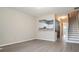Open-concept living area with gray wood floors next to an eat-in bar and stairs at 2709 Heathrow Dr, Lawrenceville, GA 30043