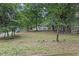 Expansive backyard with mature trees and a view of the house in the distance at 5666 Fawn Dr, Powder Springs, GA 30127
