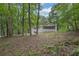 View of a sloped backyard with the house featuring a screened-in porch at 5666 Fawn Dr, Powder Springs, GA 30127