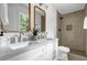 Bathroom with double vanity, modern fixtures, and walk-in shower with custom tile work and a niche at 5666 Fawn Dr, Powder Springs, GA 30127