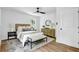 Bedroom with neutral decor, modern lighting, wood floors, and a large window providing plenty of natural light at 5666 Fawn Dr, Powder Springs, GA 30127
