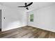 This bedroom features wood-look floors, a ceiling fan, and a window at 5666 Fawn Dr, Powder Springs, GA 30127
