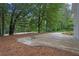 Large concrete driveway adjacent to a home, lined with mature trees at 5666 Fawn Dr, Powder Springs, GA 30127