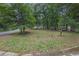 View of a large front yard with mature trees and residential street at 5666 Fawn Dr, Powder Springs, GA 30127