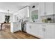 Modern kitchen featuring white cabinets, stainless steel appliances, light countertops and light wood floors at 5666 Fawn Dr, Powder Springs, GA 30127