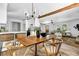 Open concept living room and kitchen with light wood floors, exposed beam, white cabinets, and modern lighting at 5666 Fawn Dr, Powder Springs, GA 30127