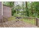 Wooden back deck and a grill overlooking the backyard at 9383 Woodknoll Way, Jonesboro, GA 30238