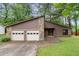 View of a single-story home featuring a 2-car garage, stone accents, and a well-manicured lawn at 9383 Woodknoll Way, Jonesboro, GA 30238