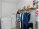 Functional laundry room equipped with washer, dryer, and storage shelving at 9383 Woodknoll Way, Jonesboro, GA 30238