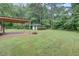 Large backyard featuring a covered patio, firepit, garage, and lush greenery at 122 Vickery Dr, Fairburn, GA 30213