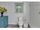 Bright bathroom features a toilet, walk-in shower, a window, and a blue cabinet at 122 Vickery Dr, Fairburn, GA 30213