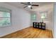 Bedroom has hardwood floors, two windows, and a ceiling fan with a light at 122 Vickery Dr, Fairburn, GA 30213