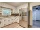 Well-lit kitchen features a stainless steel refrigerator and white cabinets with a window above the sink at 122 Vickery Dr, Fairburn, GA 30213