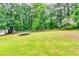 Expansive backyard with a trampoline and wooden fence, offering a safe and fun outdoor play area at 2200 E Lake E Rd, Mcdonough, GA 30252