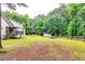 Large backyard with various outbuildings, including a shed and a covered area, providing ample storage and recreational space at 2200 E Lake E Rd, Mcdonough, GA 30252