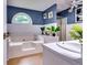 Bright bathroom with large tub, a window, blue accent wall and a shower at 2200 E Lake E Rd, Mcdonough, GA 30252
