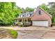 Charming brick and siding home with a two-car garage and a inviting front porch surrounded by lush trees at 2200 E Lake E Rd, Mcdonough, GA 30252