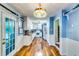 Bright galley kitchen hallway with white cabinets, a decorative light fixture, and hardwood floors at 2200 E Lake E Rd, Mcdonough, GA 30252