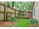 Backyard featuring a wooden fence with a gate, bordered by lush greenery and a well-maintained lawn at 4611 Dogwood Rd, Pine Lake, GA 30072