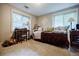 Neutral bedroom featuring a daybed with decorative pillows and a quaint desk area under a bright window at 4611 Dogwood Rd, Pine Lake, GA 30072
