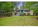 Beautiful house with light-colored siding, a blue front door, and a lush green lawn and mature trees at 4611 Dogwood Rd, Pine Lake, GA 30072