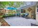 Outdoor patio with a seating area shaded by an umbrella, lush greenery, and decorative plant display at 4611 Dogwood Rd, Pine Lake, GA 30072