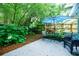 Outdoor patio with a seating area shaded by an umbrella, surrounded by lush greenery and a fenced perimeter at 4611 Dogwood Rd, Pine Lake, GA 30072