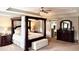 Stylish main bedroom with a four-poster bed, tray ceiling, and chic decor at 558 Hideaway Dr, Jonesboro, GA 30238