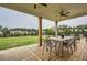 Covered backyard deck with dining table and ceiling fans, overlooking a large green lawn at 6168 Sweet Birch Ct, Acworth, GA 30101