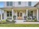Inviting front porch with double doors, stylish seating, potted plants and classic white columns at 6168 Sweet Birch Ct, Acworth, GA 30101