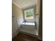Modern soaking tub nestled in marble-like tile beneath a window at 1119 Plantation Se Dr, Conyers, GA 30094